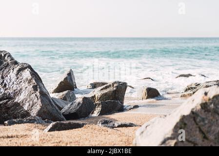 Paysage pittoresque de la mer orageux avec des vagues mouettes écrasant sur des pierres rugueuses sur la plage rocheuse par temps ensoleillé en été Banque D'Images