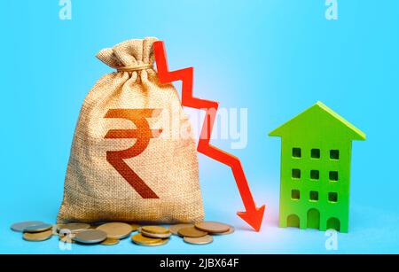 Sac d'argent à la roupie indienne avec flèche vers le bas et maison verte. Rentabilité de l'utilisation des écotechnologies vertes dans la modernisation de la construction de logements. Réduire Banque D'Images