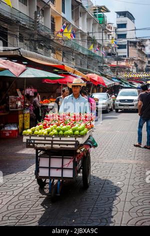 Homme avec chariot de fruits à la recherche de clients de la cuisine de rue à Chinatown, Bangkok, Thaïlande. Banque D'Images