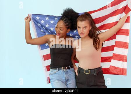 Le concept de l'unité des différentes nations et jour de l'indépendance des etats-unis - juillet 4. Femme afro-américaine et femme caucasienne portant le drapeau des états-unis Banque D'Images