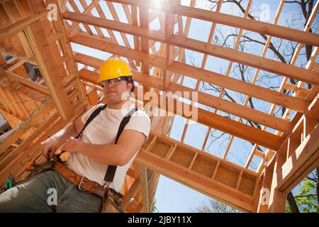 Vue à angle bas d'un homme travaillant sur un chantier de construction résidentielle Banque D'Images