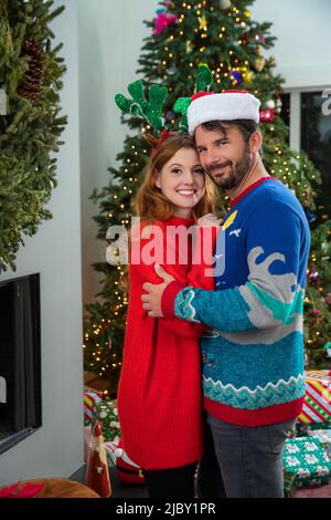 Portrait d'un jeune couple caucasien vêtu de vêtements de vacances en regardant dans l'appareil-photo souriant. Banque D'Images