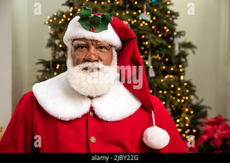 Homme noir âgé habillé comme le Père Noël, regardant dans la caméra avec s expression sérieuse. Banque D'Images