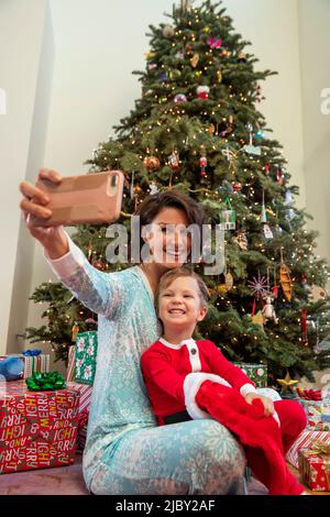 Mère et fils prenant un selfie devant l'arbre de Noël Banque D'Images