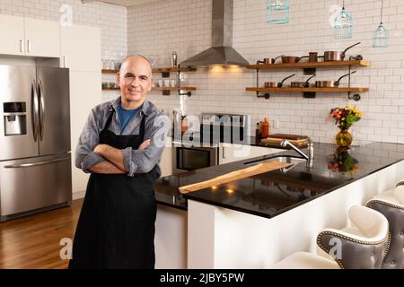 Portrait de l'homme debout dans le pilon de cuisine dans l'appareil photo avec confiance. Banque D'Images