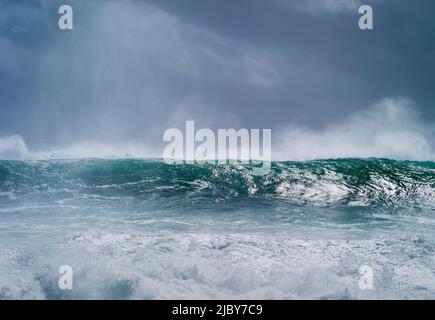 Vague de curling et de rupture pendant le cyclone Ola avec ciel orageux Banque D'Images