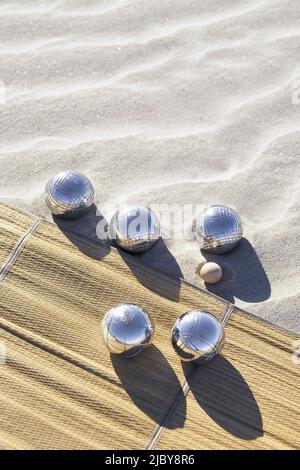 Boules de pétanque sur tapis d'herbe et sable à la plage Banque D'Images