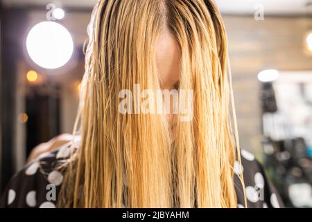 Jeune femme ayant une coupe de cheveux au salon de boutique Banque D'Images