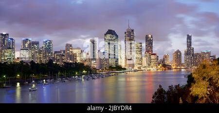 Panorama de la ville de Brisbane illuminé en début de soirée et vue sur les bateaux amarrés dans le fleuve Brisbane, pris de Kangaroo point Banque D'Images