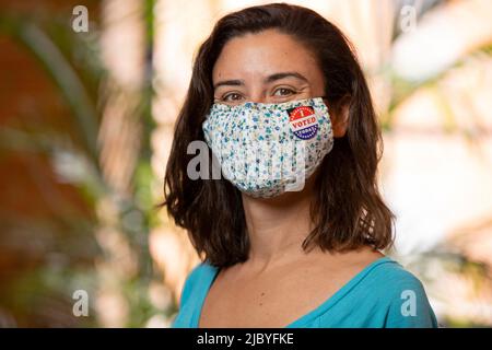 Femme caucasienne portant un masque en tissu à imprimé floral et un autocollant J'ai voté aujourd'hui sur le masque Banque D'Images