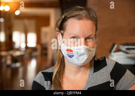 Femme caucasienne portant un masque et un autocollant J'ai voté aujourd'hui sur le masque Banque D'Images