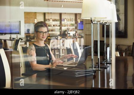 Caucasian woman using laptop at restaurant table Banque D'Images