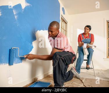 African American couple painting wall Banque D'Images