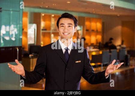 Homme d'affaires chinois en bar accueille les clients Banque D'Images