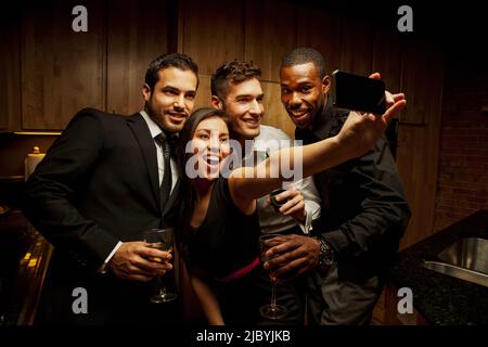 Les amis de boire à cuisine du parti et de prendre des photos Banque D'Images