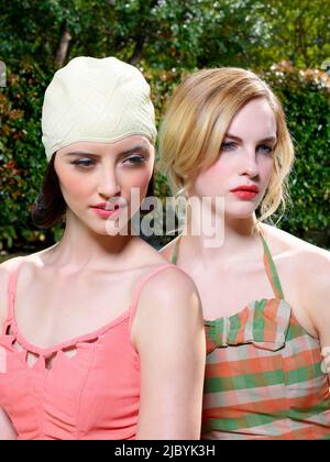 Portrait en gros plan de deux femmes en maillots de bain de style vintage, accrobranche dehors par une piscine. Banque D'Images