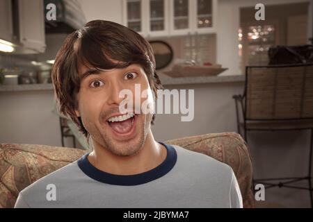 Heureux mixed race man in living room Banque D'Images