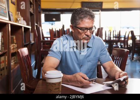 Propriétaire de l'entreprise passe à la paperasserie cafe Banque D'Images