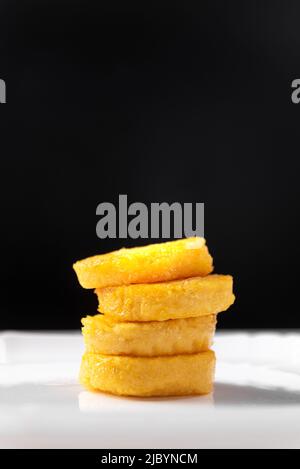 Pancakes frit polenta sur un fond blanc et noir isolé. Crêpes empilées l'une sur l'autre Banque D'Images