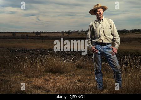 Farmer standing in field Banque D'Images