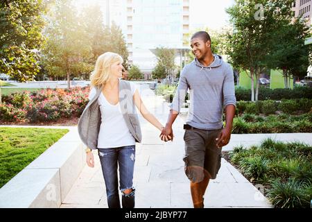 Couple walking and holding hands Banque D'Images