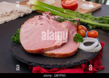 Deux morceaux de porc haché cru avec l'oignon et les tomates cerises Banque D'Images