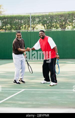 Les hommes africains jouant au tennis en double Banque D'Images