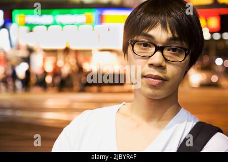 Asian man standing on urban street Banque D'Images