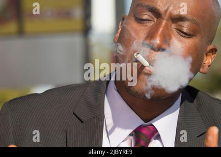 African American businessman smoking cigarette Banque D'Images