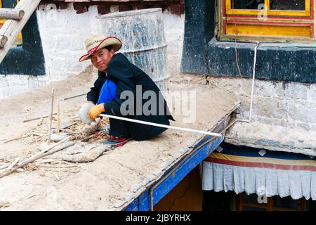 Un jeune homme tibétain de Malboro travaille dans un chantier de construction au monastère de Drepung à Lhassa, au Tibet. Banque D'Images