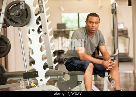 African American man resting in health club sur banc de levage de poids Banque D'Images