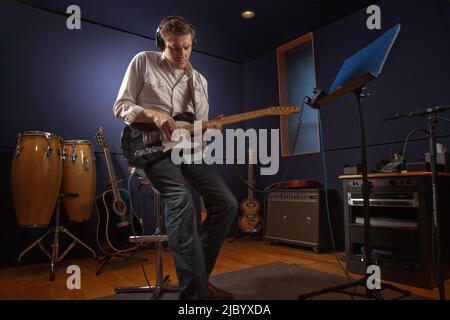 Young man playing guitar in studio Banque D'Images