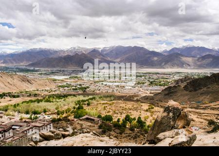 Vue majestueuse de la vallée qui se trouve sous le monastère de Drepung au pied du mont Gephel tandis que deux faucons survolent. Banque D'Images