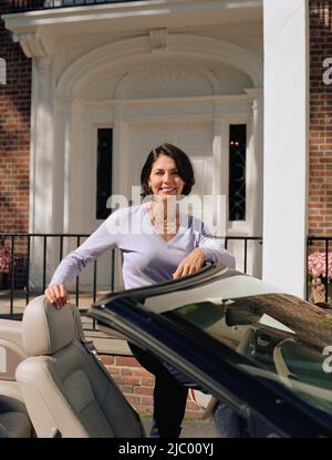 Femme debout à côté de cabriolet Banque D'Images