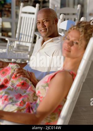 Middle-aged African American couple assis dans des chaises à bascule à l'extérieur Banque D'Images