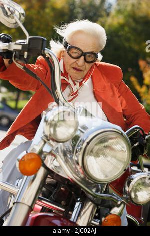 Femme âgée la conduite d'une moto Banque D'Images