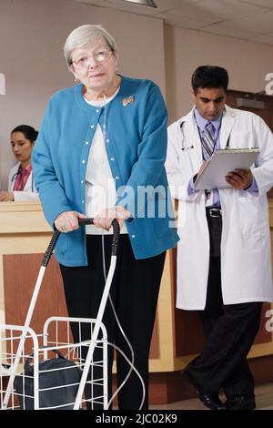 Femme âgée à l'aide d'un déambulateur et un respirateur Banque D'Images