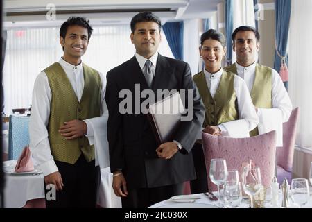 Serveurs smiling for the camera in restaurant Banque D'Images