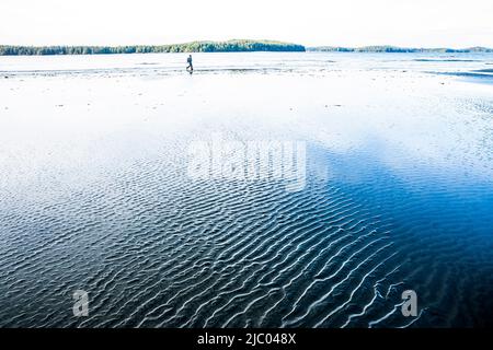 Une femme qui marche et se présente à marée basse sur la plage Tonquin, près de Tofino, C.-B., Canada. Banque D'Images