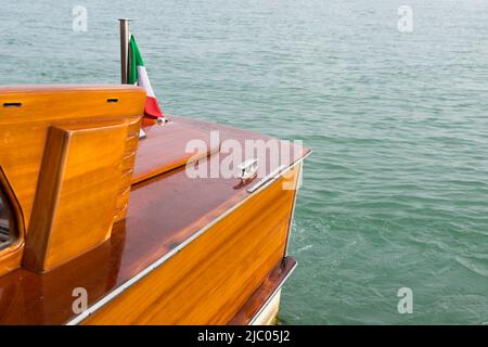 Partie d'un bateau à moteur en bois de luxe et élégant avec un drapeau italien sur la mer Méditerranée à Venise, Italie. Banque D'Images