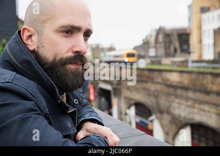 Homme regardant sur le rebord du bâtiment depuis la terrasse sur le toit Banque D'Images