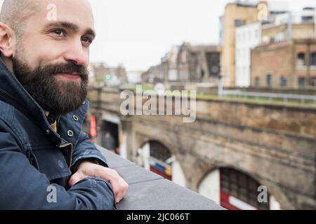 Homme regardant sur le rebord du bâtiment depuis la terrasse sur le toit Banque D'Images