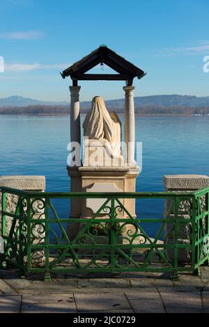 Statue de Madonna sur le front de mer sur le lac alpin majeur lors d'une journée ensoleillée à Arona, Piémont en Italie. Banque D'Images