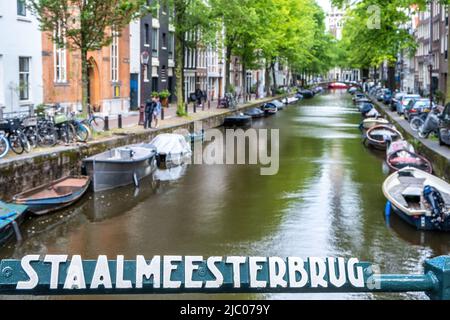 Staalmeestersbrug, Steel Masters Bridge à Amsterdam, pays-Bas. Bateaux amarrés le long du canal, maisons traditionnelles, vue du pont Banque D'Images