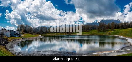 lac alpin au printemps avec des nuages dans le ciel bleu Banque D'Images