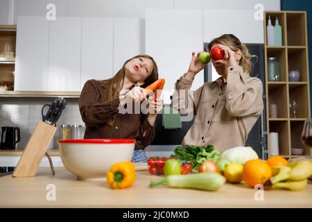 Mère et sa fille adulte préparant des aliments sains et s'amuser dans la cuisine Banque D'Images