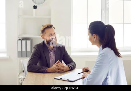 Le responsable des ressources humaines professionnel de sexe féminin conduit une entrevue avec un candidat à un poste de sexe masculin confiant. Banque D'Images