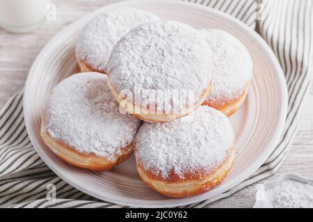 Beignes Berliner remplies de confiture de fraise sur plaque blanche, vue de dessus. Beignes Berliner mangées traditionnellement pour les fêtes de carnaval, le nouvel an Banque D'Images