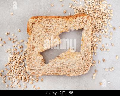 Pain brun avec une flèche coupée indiquant une augmentation du coût du pain et des aliments de base dans le monde entier Banque D'Images