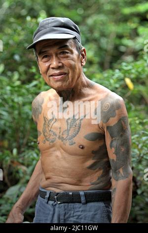 Portrait de Ramping, membre de la communauté traditionnelle Dayak IBAN à Sungai Utik, Kalimantan occidental, Indonésie. Ancien avec de nombreux tatouages traditionnels sur son corps, M. Ramping était l'une des personnes les plus âgées de la communauté, jouant un rôle important dans les rituels et les traditions. Banque D'Images